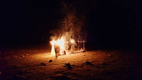 People watching drone fly through burning fire at night Stock Footage 253975276