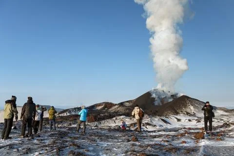 People watching the eruption volcano, ejecting lava, ash, steam and gas Stock Photos
