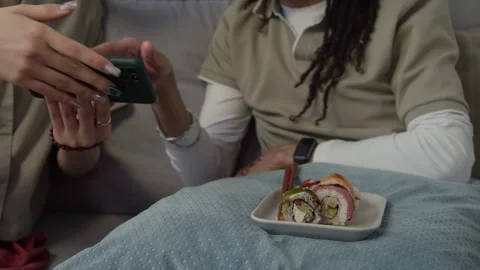 People Watching Tutorial on Phone while Eating Sushi Rolls with Chopsticks Vídeos de archivo 331196357