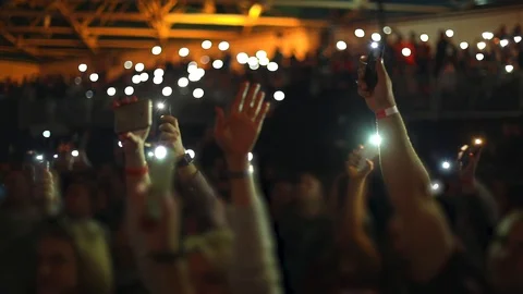 People waving hands with smartphones with flashlight. Live music concert Stock Footage 98123553