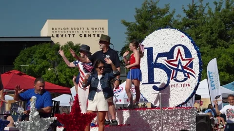 People waving from a parade float with a 150th anniversary sign 動画素材 340940885