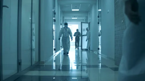 People wear protective suit while working in hospital during pandemic. Stock Footage 130388384