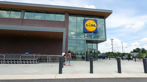 People wearing masks entering and exiting LIDL on Stone Mountain Hwy Stock Footage
