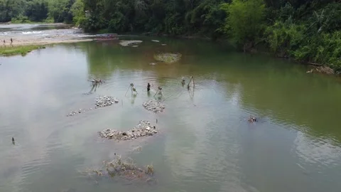 People who are mining stone manually without heavy equipment in a body of wat Stock Footage 256291312
