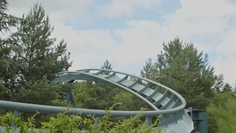 People in a wild rollercoaster go through a sharp bend at high speed in slow Video stock 338072064