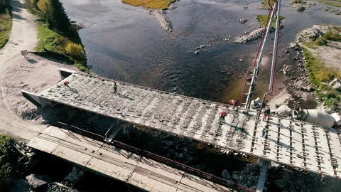 People Workers Build a Bridge across the River. Aerial View Stock Footage 130950411