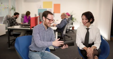 People working together in an office space discussing ideas and sharing a Stock Footage 343017128