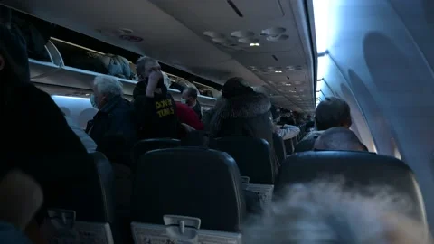 People in worm clothes leaving the plane after landing Stock Footage 150972894