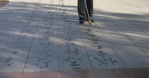 People wrting Buddhist scriptures on the ground with Chinese brush in Zhangye Stock Footage 122350907