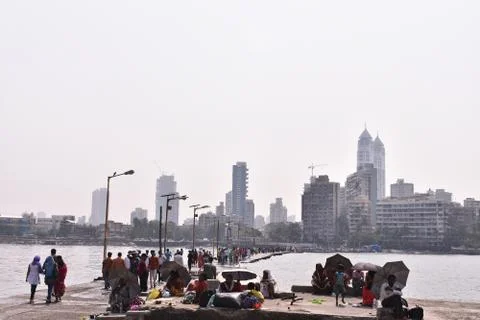 Peoples walking in the path constructed between the ocean In Mumbai Stock Photos