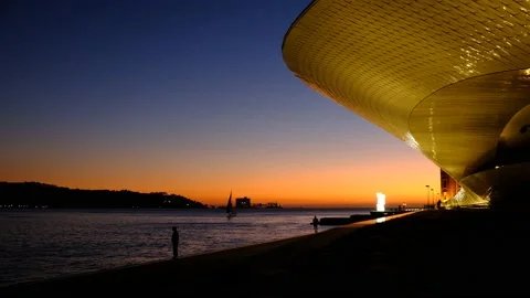 Peopple jogging and walking next to river Tejo in sunset Stock Footage 140460129