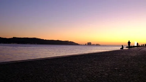 Peopple jogging next to a river Tejo in sunset Stock Footage 140460216