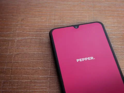 Pepper app launch screen with logo on the display of a black mobile smartphon Stock Photos