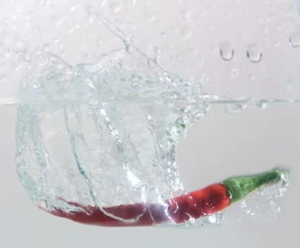 Pepper falling into water Foto stock