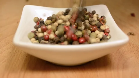 Pepper falling into white porcelain container Stock-Footage 101356409