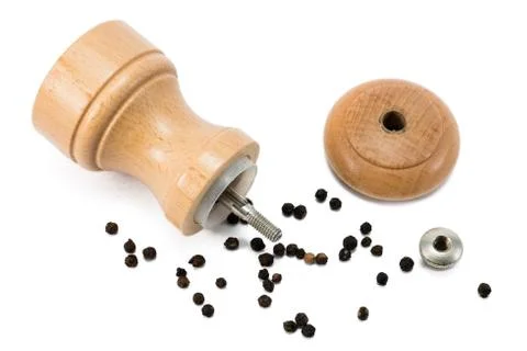 Pepper mill lying in pepper corn Stock Photos