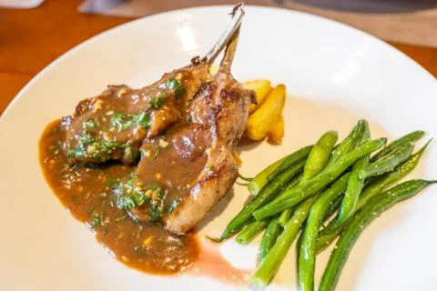 Pepper sauce lamb chops with basil and string beans Foto stock