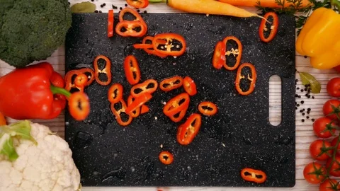 Pepper slices falling on chopping board - slow motion, top view Stock-Footage 104463977