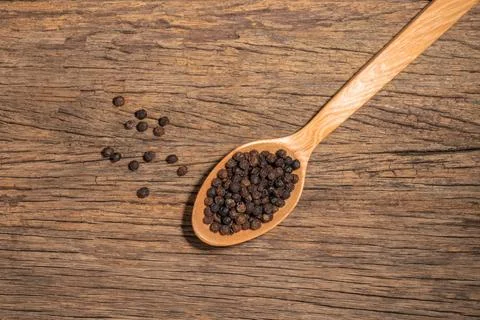 Pepper in spoon on wood table. Stock Photos