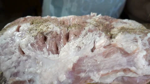 Pepper sprinkle on a piece of raw meat in slow motion. Stock Footage 129550143