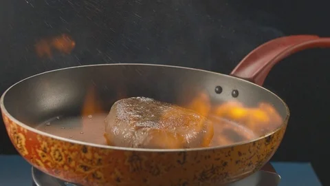 Pepper is thrown on hot pan with grilled beef steak. Slow Motion HD Stock Footage 112088130