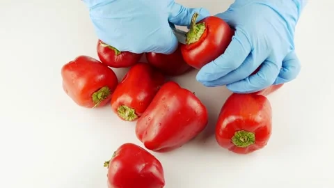 Pepper on a white table.Red pepper is peeled with gloved hands. Vídeos de archivo 140046082