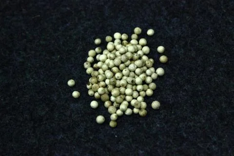 Peppercorns on black cloth Stock Photos