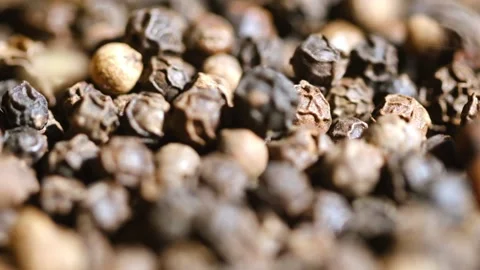 Peppercorns falling close up with rotation. Macro shot. Dried black pepper Stock Footage 162469167
