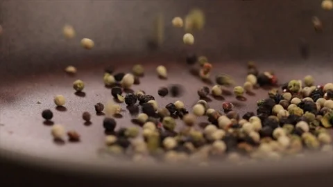 Peppercorns Jump into a Pan Closeup Stock Footage 99164794