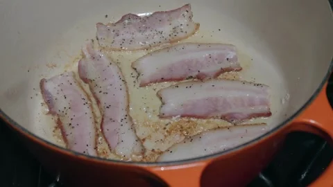 Peppered bacon rendering in an enameled cast iron Dutch oven Видео 340237454