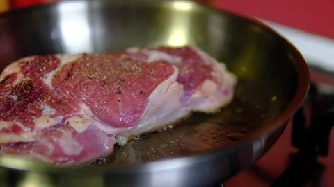 Peppered beef steak searing in stainless steel pan with raw top side and Stock Footage 346182946