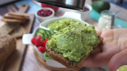 Peppering An Avocado Toast In A Hand. Video stock 131728769