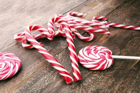 Peppermint Candy Canes in Heart Shape on old wooden background. Christmas Stock Photos