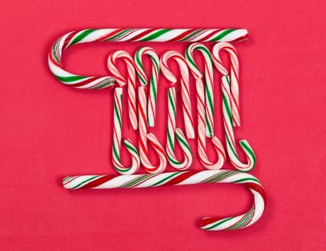 Peppermint candy canes in pattern shape on red background 스톡 사진