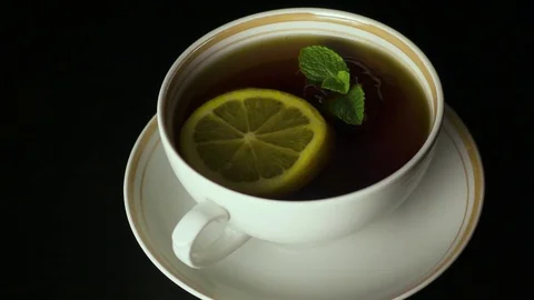A peppermint leaves falls into the tea. Slow motion Stock Footage 74268064