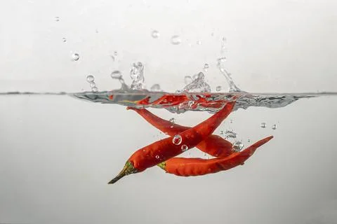 Pepperoni drops in water Stock Photos