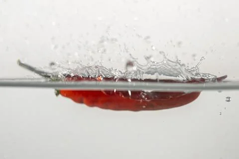 Pepperoni drops in water Stock Photos