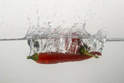 Pepperoni drops in water Stock Photos