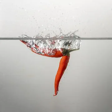 Pepperoni drops in water Stock Photos