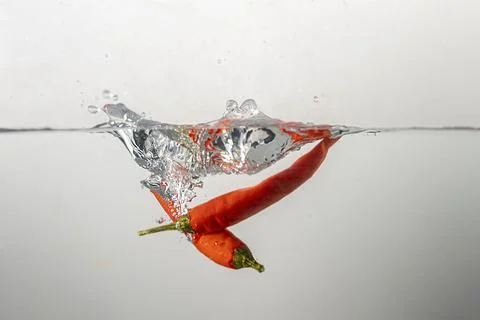 Pepperoni drops in water Stock Photos