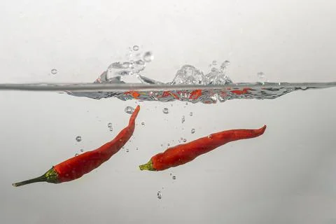 Pepperoni drops in water Stock Photos