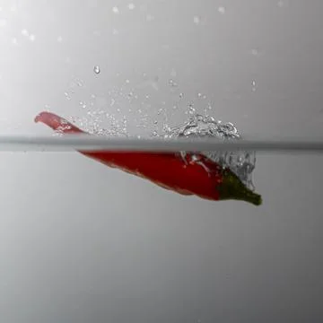 Pepperoni drops in water Stock Photos