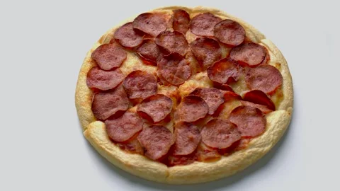 Pepperoni pizza spinning on white table Stock Footage 309122435