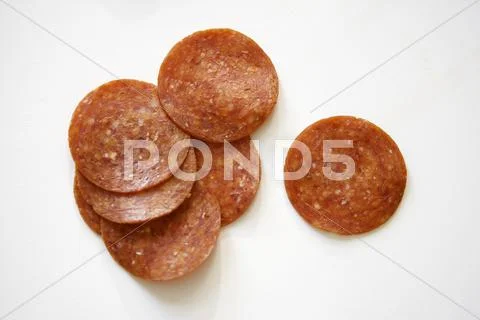 Pepperoni Slices on White Background Stock-Fotos