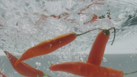 Peppers falling in water Stock Footage 98300418