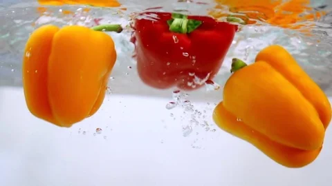 Peppers falling in water in slow motion Stock Footage 76041149