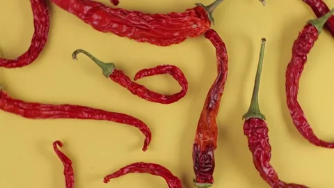 Peppers pattern, dry pods of red hot chili pepper close-up on a yellow backgr Video stock 176952898