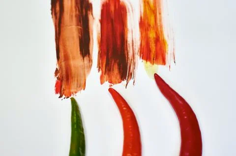 Peppers on a white background with multi-colored paint Stock Photos