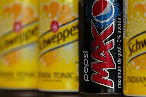 Pepsi Max can in a row next to out of focus Schweppes tonic bottles Stock Photos