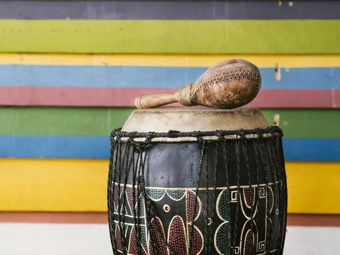 Percussion instruments alongside multicolored stripes wall with copy space Stock Photos